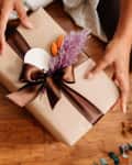 Pretty wrapped present in brown paper, brown ribbon, dried flowers