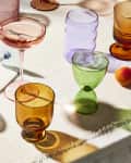 Colorful glasses on linen casting colorful shadows