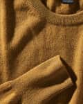 Closeup photo of a brown cashmere sweater. Tag is showing, reading "100% cashmere"