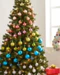 Christmas tree with colorful ornaments, festive decor, and a cozy chair with candy-themed pillows by a window.