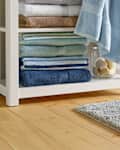 Classic Cotton Bath Mat in bathroom with shelf of towels