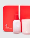 Red gift set with a perfume bottle and a scented candle in frosted glass containers.