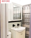 Small bathroom with mirrored cabinet, beige vanity, and striped shower curtain.