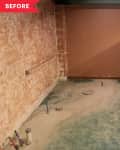 Unfinished basement room with exposed pipes, concrete floor, and brown walls.