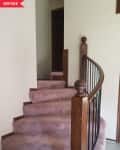 Curved staircase with pink carpet and wooden railing, labeled "Before."