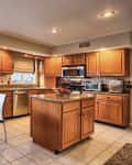 Before: Kitchen with orangey wood cabinets and beige walls