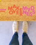 Brown doormat with "Makeover Madness" logo