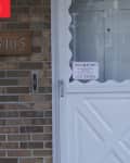 Before: Dingy white front door with scalloped edges against brick siding