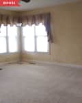 Before: Beige living room with maroon curtains