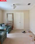 Before: beige living room with beige carpeting and semi-flushmount overhead light