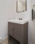 Before: Stark white bathroom with greige vanity