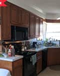 Before: dark wood kitchen with beige floors