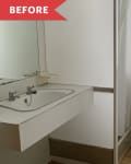 Small bathroom with a wall-mounted sink, mirror, shower curtain, and window with sheer curtains.