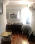 Small room with wooden floors, air conditioner, exercise ball, and yoga mat.