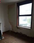 Before: living room with peeling plaster and dingy colors