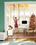 young girl on swing hanging from living room ceiling