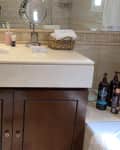 Before: brown vanity with travertine tile background