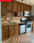 Before: kitchen with brown counters, floors, cabinets, and backsplash