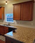 Before: Dated kitchen with dark wooden cabinets and floors and tan countertops