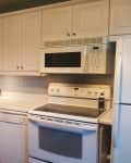 Before: Dated kitchen with white cabinets and white appliances