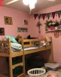 Before: Kids' bedroom with lofted bed, pink walls, and garland