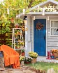 View of fall porch with seating, blankets, and potted plants