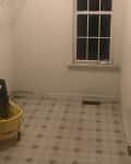 Before: Laundry room with white walls and faded vinyl floors