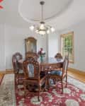 Before: Dining room with white walls, traditional furniture, and traditional chandelier