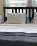 Bedroom with yellowish walls and black basic IKEA bed