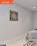 Small bedroom with a single bed, teal and beige pillows, ornate mirror, and framed artwork on a light gray wall.