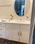 Double sink with oval mirrors and white cabinets