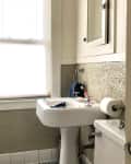Before: green popcorn bathroom wall with sink, toilet, and tub