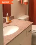 Bathroom with orange shower curtain, granite countertop, white sink, and toiletries on the counter.
