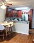 Before: a kitchen with wooden cabinets and a small rectangular dining table