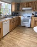Before: a kitchen with brown wooden cabinets and white appliances