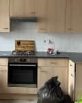 Before: Kitchen with light wood cabinets and white brick backsplash