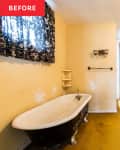 Clawfoot bathtub, wooden vanity, and yellow walls in a vintage bathroom with floral curtains.
