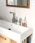 Before: a white bathroom sink against white tile walls