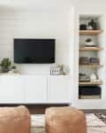 A white-and-wood media unit surrounding a TV, built around an IKEA BESTA console.
