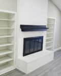 Empty living room with white walls, fireplace and built-in shelves