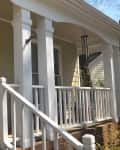 Front porch with white railing before renovation.