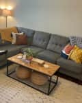 Living room with grey sectional before installing built-in shelving.