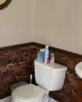 Bathroom with wallpaper wainscoting before renovation.