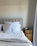 Before: Bedroom with tufted headboard and blank tan walls