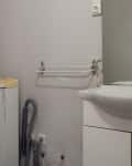 Before: Basic grayish white bathroom with washing machine in corner