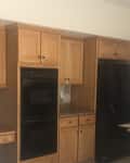 Before: Dated kitchen with tan cabinetry and beige walls