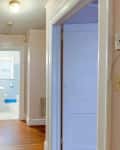 Doorways line a light pink painted hallway before renovation.
