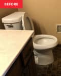 small square brown tile floor, old wood panel vanity, white counter top, white toilet, grey towel, beige walls