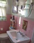 white bathroom with pink tile and gray floor before remodel