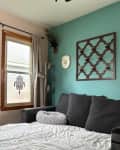 Guest bedroom with sleeper sofa and teal accent wall